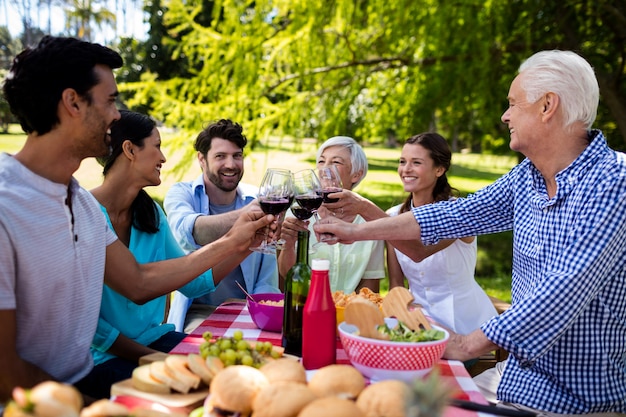 Famiglia felice che tosta un bicchiere di vino