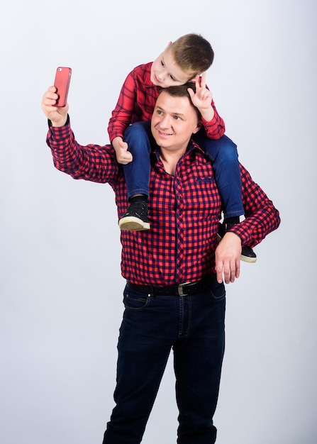 Happy family together fathers day enjoying time together\
childhood parenting father and son in red checkered shirt small boy\
with dad man funny selfie with father fathers day concept