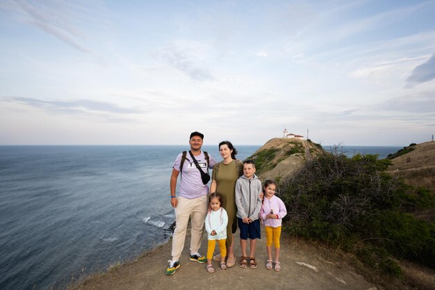 Happy family on the top of a mountain with a lighthouse in the background