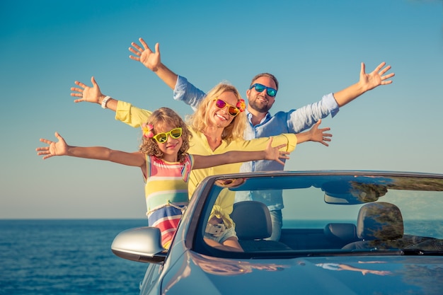 Photo happy family travel by car people having fun in blue cabriolet summer vacation concept