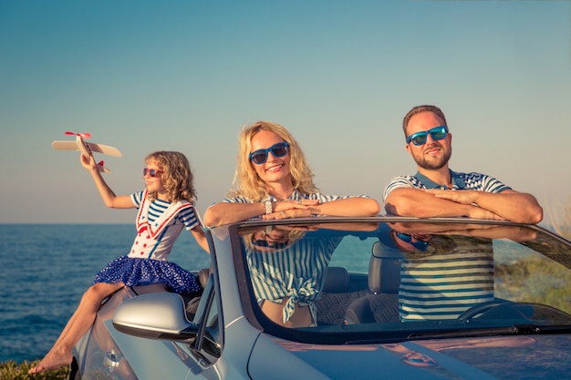 車で幸せな家族旅行青いカブリオレで楽しんでいる人々夏休みのコンセプト