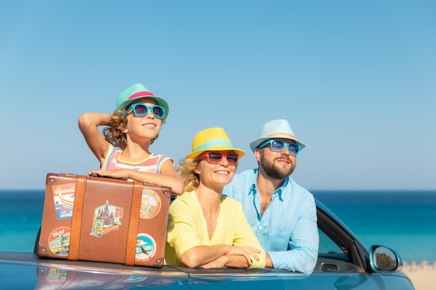 Buon viaggio in famiglia in auto al mare madre, padre e figlia, divertirsi in cabriolet blu concetto di vacanza estiva