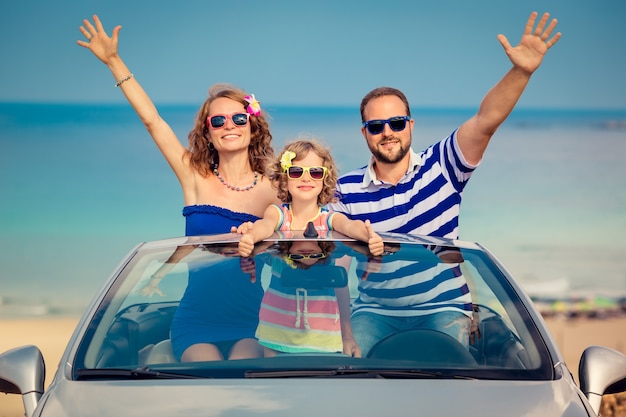 Happy family travel by car to the sea people having fun in\
cabriolet summer vacation concept