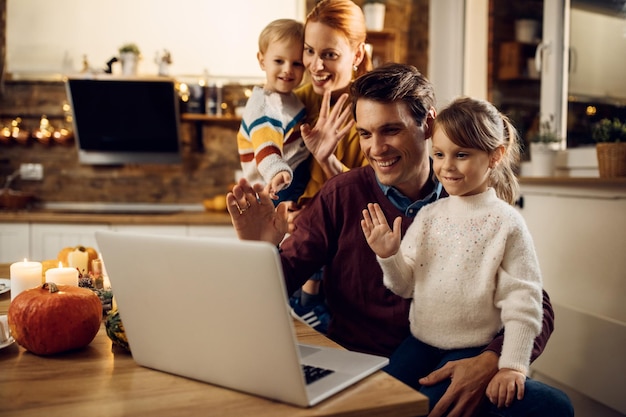 Happy family using laptop and making video call on Thanksgiving at home