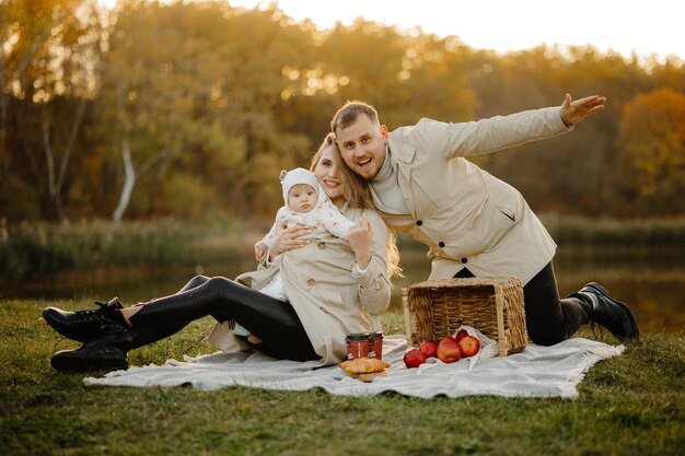 Happy family walk in autumn in the park. The child, mother, father are having fun in the park. Famil