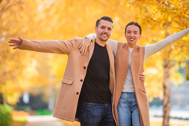 Happy family walking in autumn park on sunny fall day