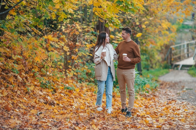 Happy family walking in autumn park on sunny fall day