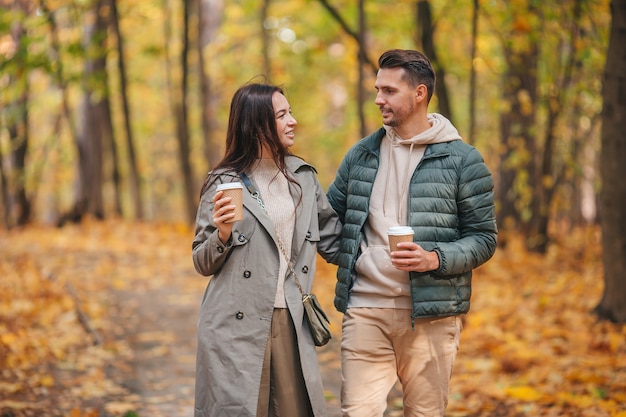 Happy family walking in autumn park on sunny fall day