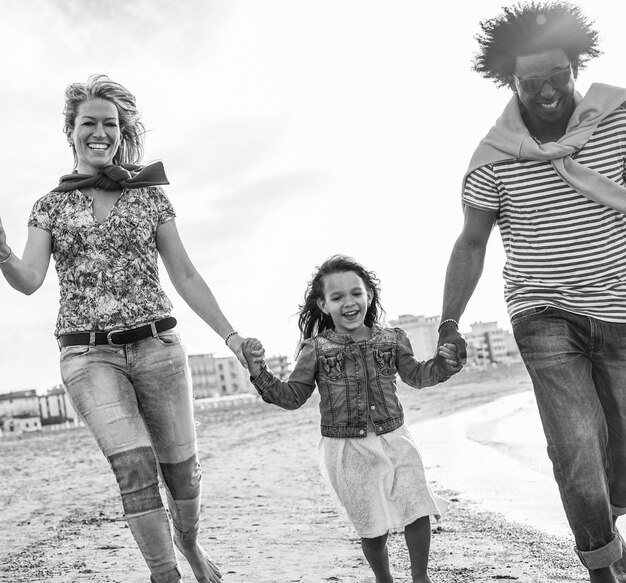 Foto famiglia felice che cammina sulla spiaggia contro il cielo