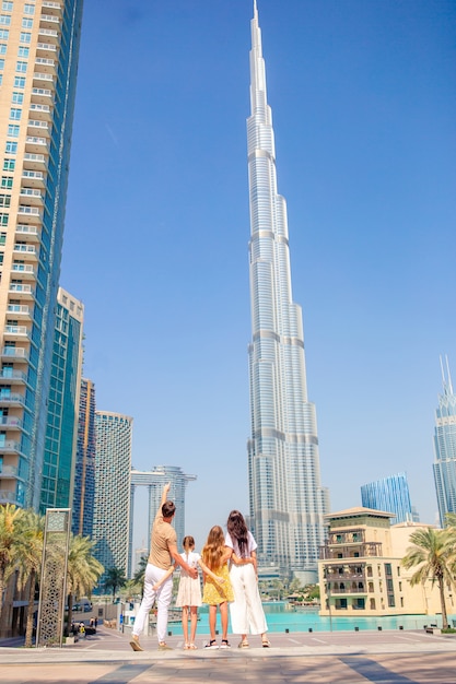 Happy family walking in Dubai with skyscrapers