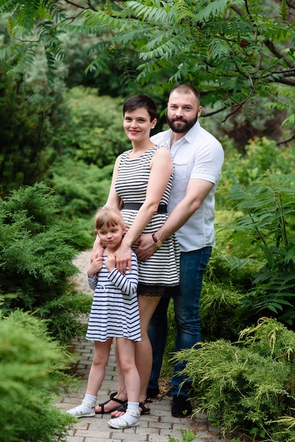 Happy family walking in the park. Pregnancy.