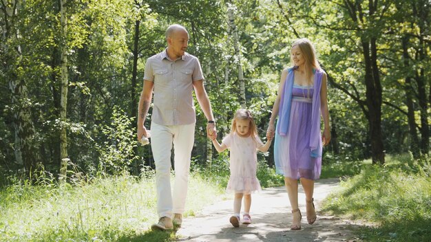 Happy family walking in the park at sunny day, telephoto