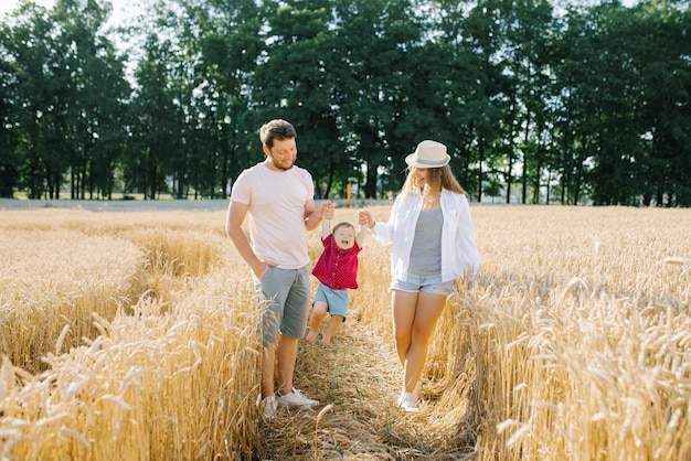 Famiglia felice che cammina nel campo di grano