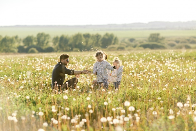 Happy family walks in nature. Dad throw their children