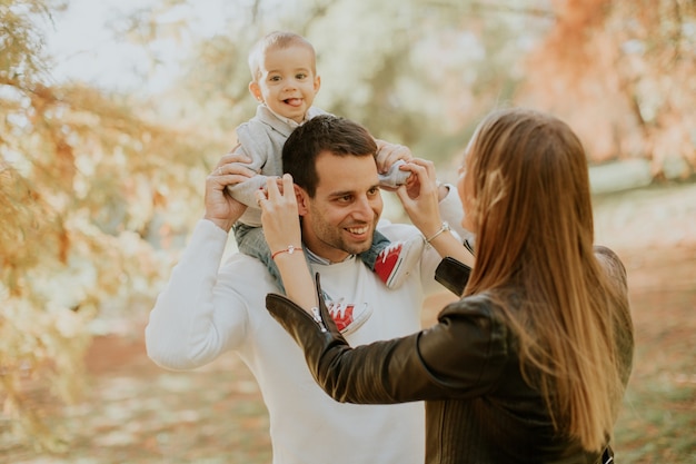 Happy family with baby boy in autumn park