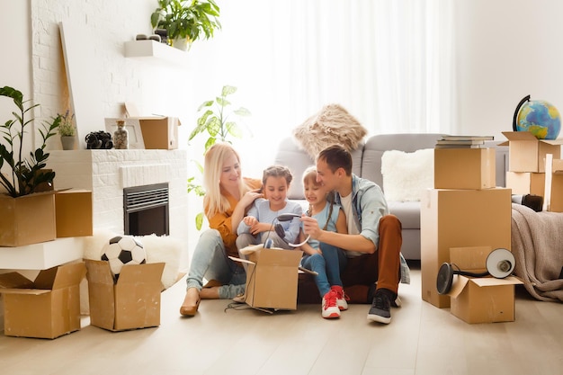 Happy family with cardboard boxes in new house at moving day.