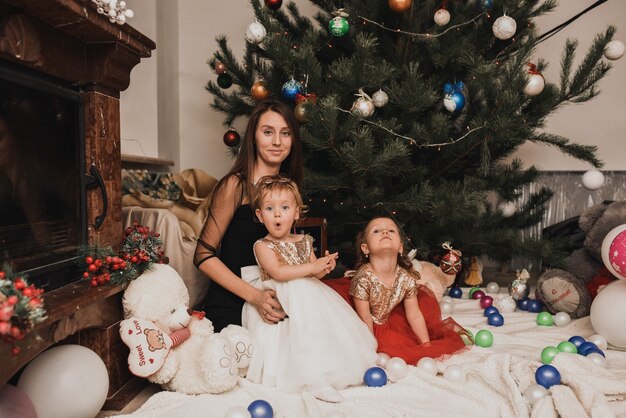 Happy family with child celebrating New Year and Christmas at decorated Christmas tree and garlands