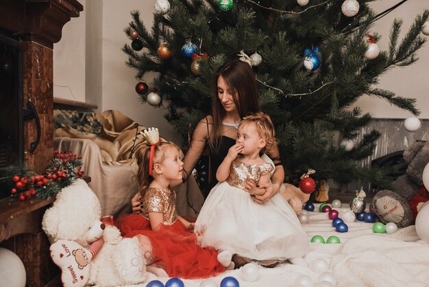 Happy family with child celebrating New Year and Christmas at decorated Christmas tree and garlands