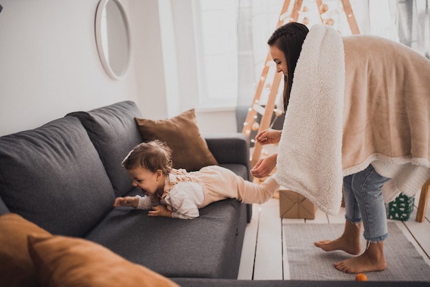 Famiglia felice con bambino che celebra il nuovo anno e il natale all'albero di natale decorato e alle ghirlande