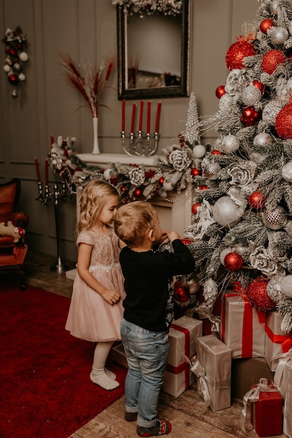 Happy family with child celebrating New Year and Christmas at decorated Christmas tree and garlands