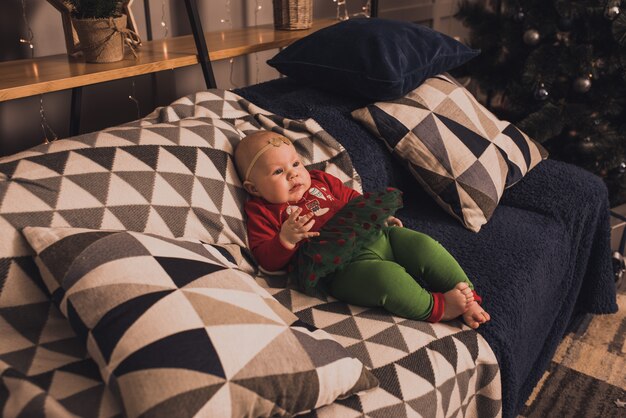 Famiglia felice con bambino che celebra il nuovo anno e il natale all'albero di natale decorato e alle ghirlande