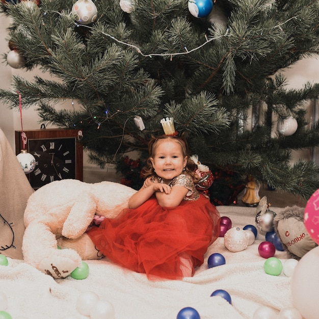 Счастливая семья с детьми, празднующими Новый год и Рождество в украшенных елочных гирляндах
