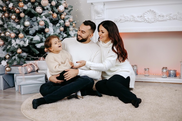 Happy family with children and Christmas gifts on floor at home