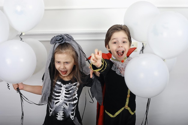 Happy family with children in costumes of witch and vampire in a house in holiday Halloween