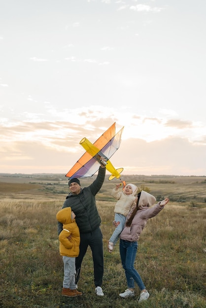 A happy family with children flies a kite and spends time together outdoors in a nature reserve Happy childhood and family holidays Freedom and space