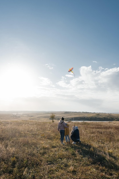 A happy family with children flies a kite and spends time together outdoors in a nature reserve Happy childhood and family holidays Freedom and space