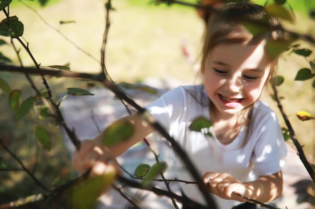 庭の芝生に座って、屋外でスイカを食べる子供たちと公園の親でピクニックをしている子供たちと幸せな家族