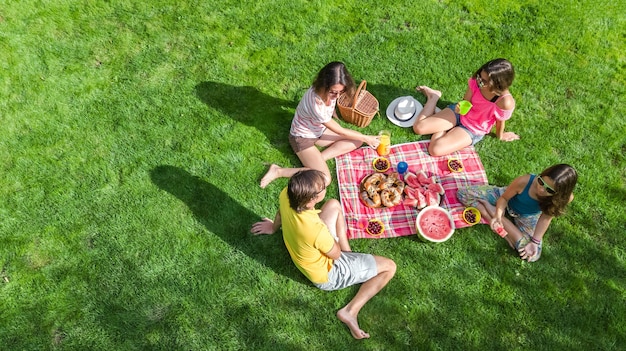 Happy family with children having picnic in park parents with kids sitting on garden grass