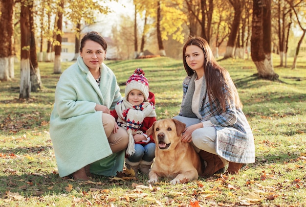 Happy family with dog in sunny autumn park