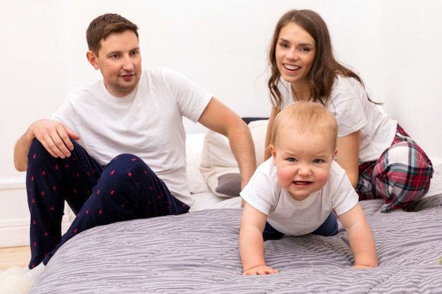 Happy family with funny toddler in bedroom