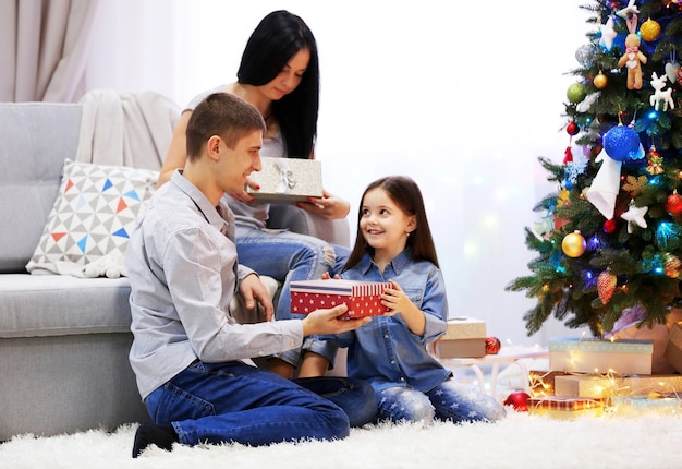 Happy family with gifts in the decorated Christmas room