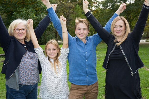 Photo happy family with hands up on the grass