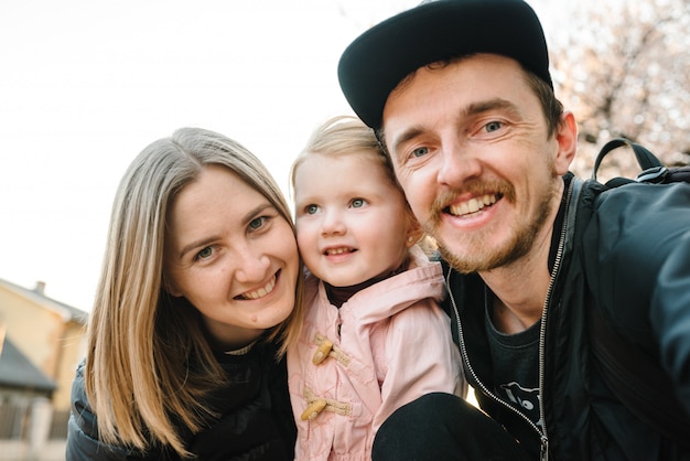 Счастливая семья с ребенком, принимая селфи портрет