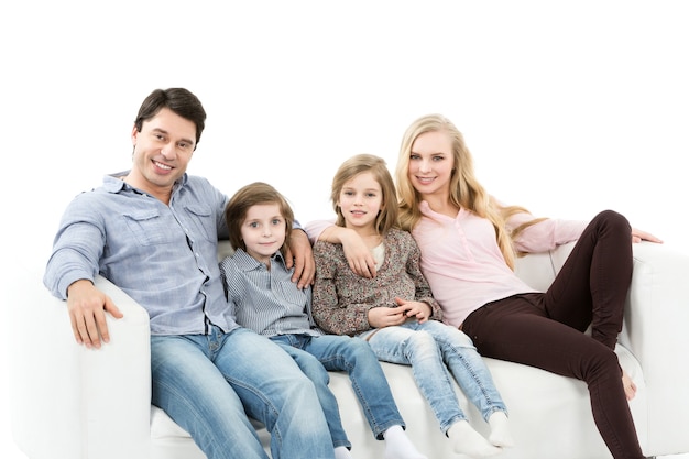 A happy family with kids on the couch isolated