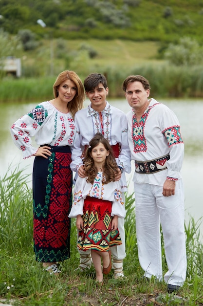 Happy family with kids in traditional romanian clothes Father mother son and daughter posing outside