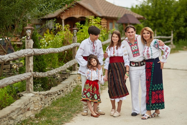 Happy family with kids in traditional romanian clothes Father mother son and daughters walking outside