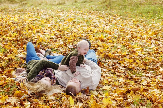 Famiglia felice con un bambino piccolo nella sosta di autunno