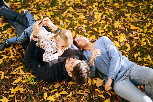 가을 공원 야외 레크리에이션에서 어린 딸과 함께 행복한 가족