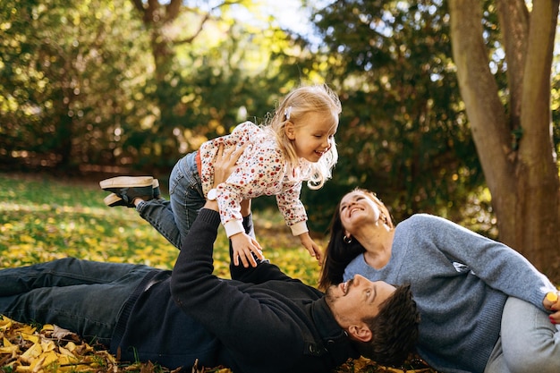 Photo happy family with little daughter in autumn park outdoor recreation