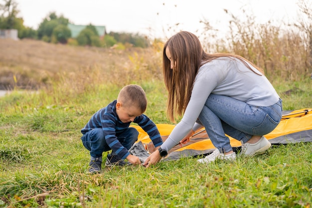 La famiglia felice con il piccolo figlio ha installato la tenda di campeggio.