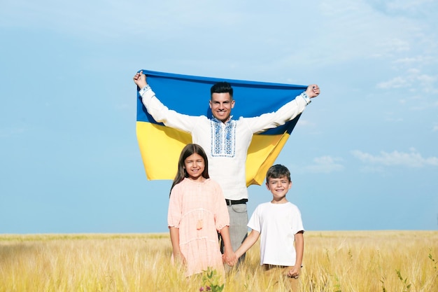 Happy family with national flag of Ukraine in field