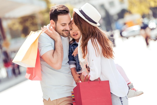 Happy family with shopping bags in city center