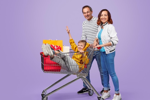 Photo happy family with shopping cart and purchases