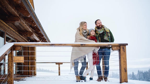 Happy family with small daughter on terrace outdoors, holiday in winter nature.