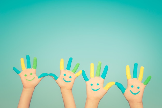 Happy family with smiley on hands against blue summer sky background