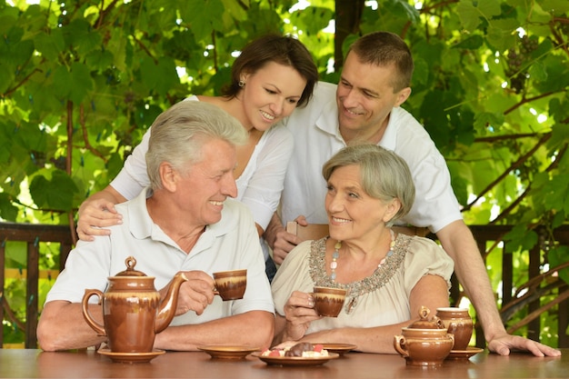 Happy family with tea sitting on the veranda